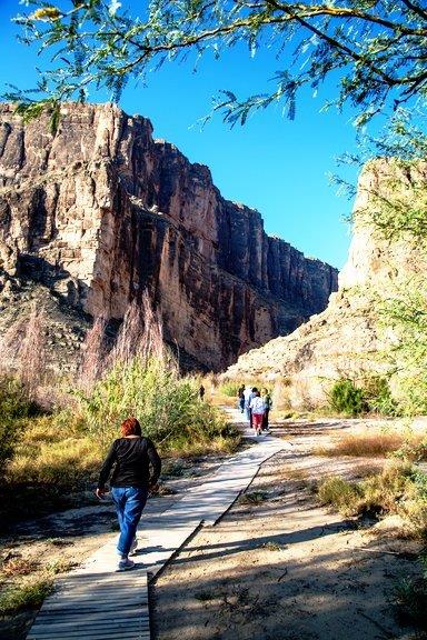 Guests on a boardwalk trail into Santa Elena Canyon on a sunny day in Big Bend National Park