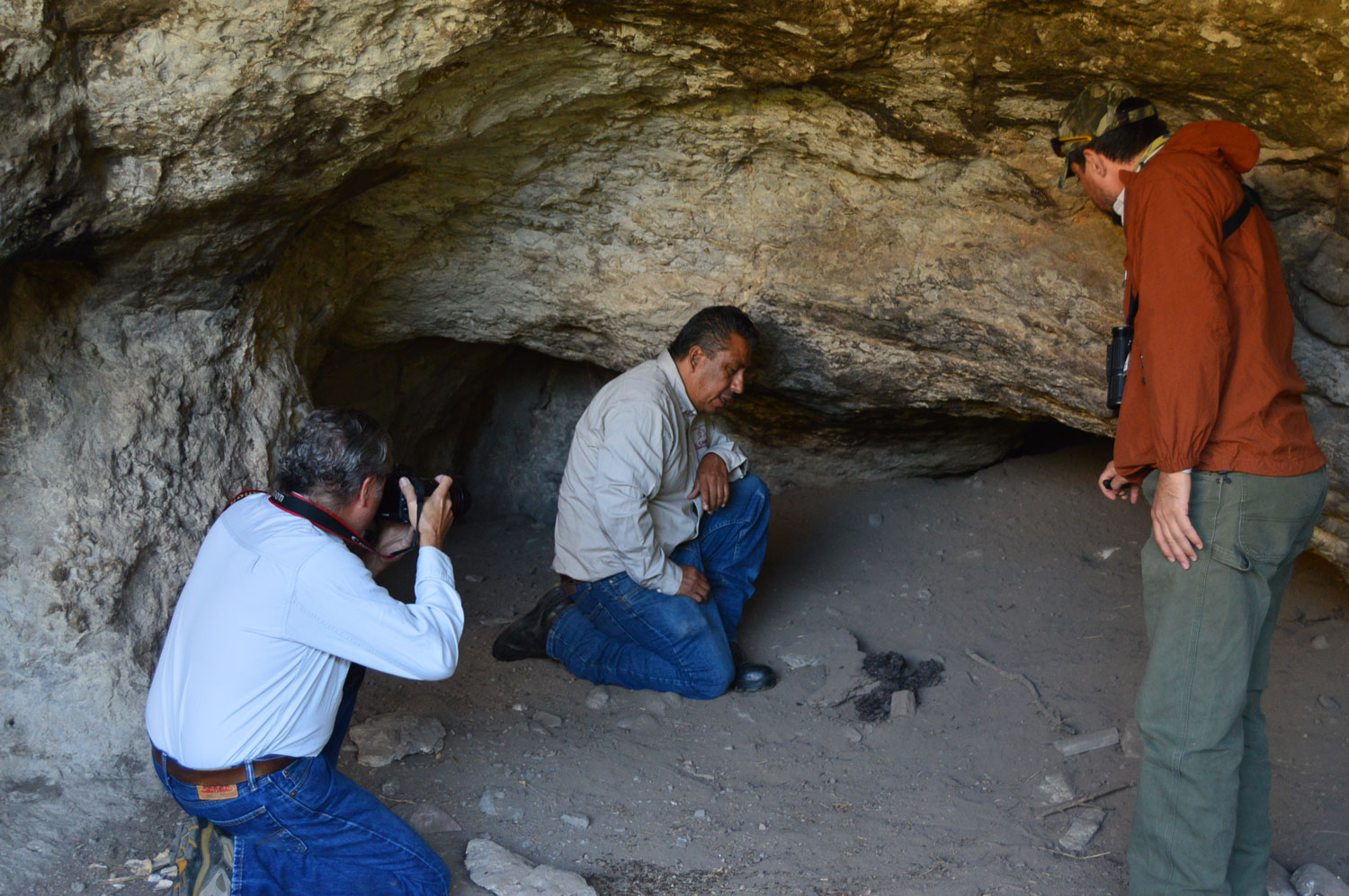 Staff biologist explaining animal sign in small cave