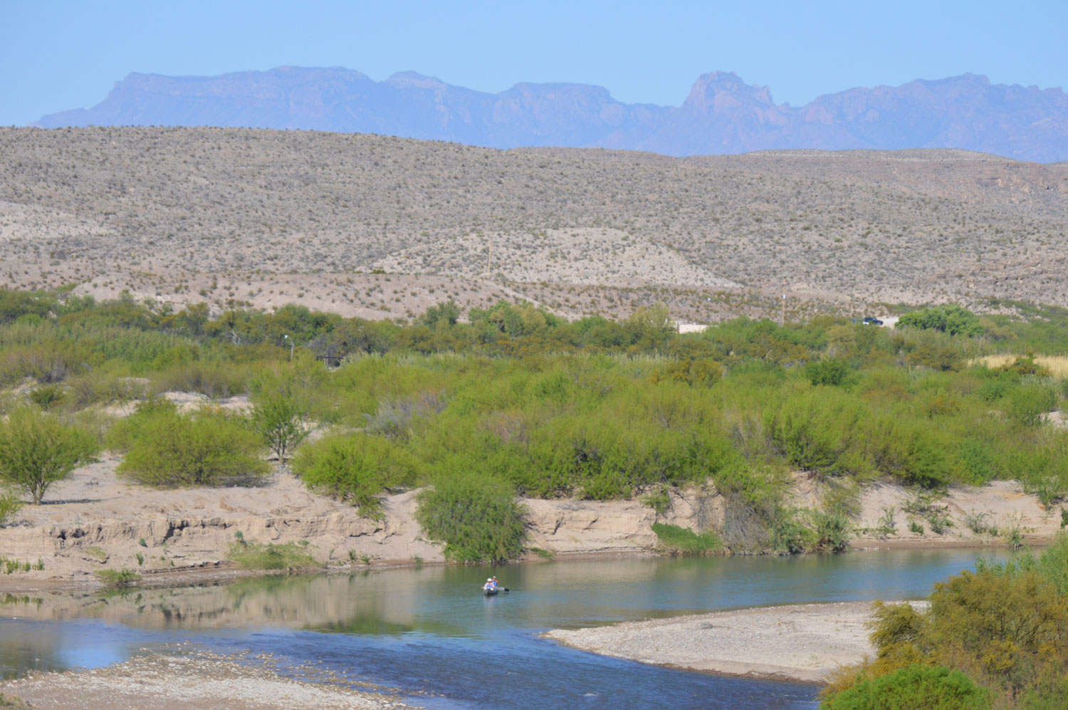 Canoe on the Rio Grande river with the Chisos Mountains in the background
