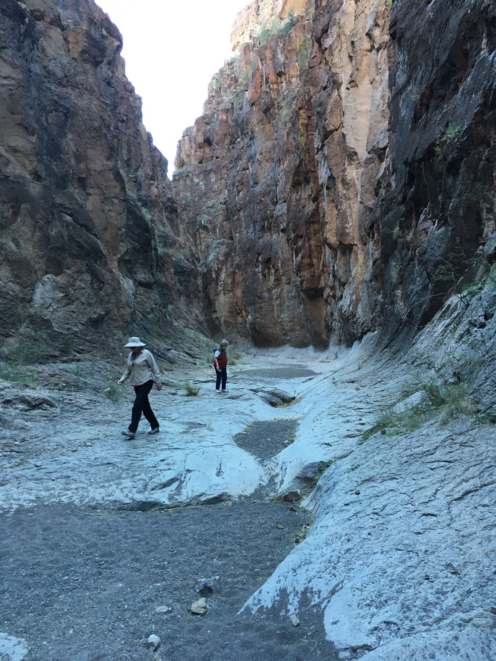 Guests hiking in the dry streambed at the bottom of Closed Canyon in the Big Bend Ranch State Park
